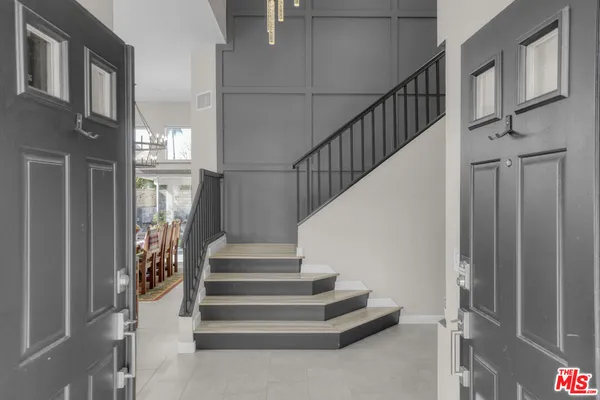 a view of staircase with lots of frames on wall and a window