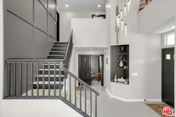 a view of staircase with lots of frames on wall and a window