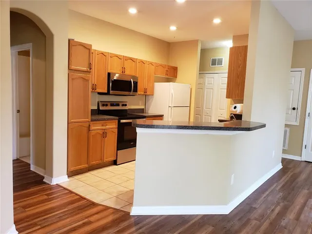 a kitchen with kitchen island granite countertop a stove and a refrigerator