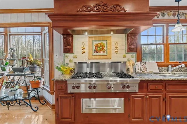 a kitchen with stainless steel appliances granite countertop a stove and a dining table