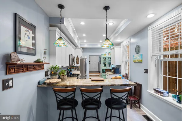 a dining room with stainless steel appliances kitchen island a table and chairs
