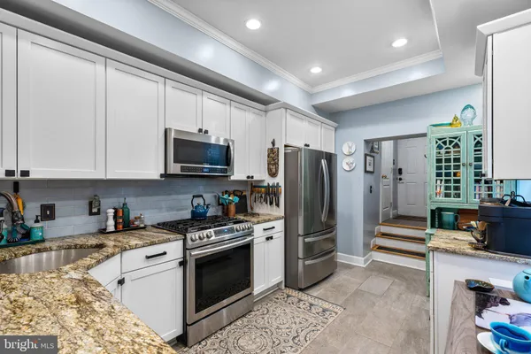 a kitchen with stainless steel appliances granite countertop a stove a refrigerator and a microwave