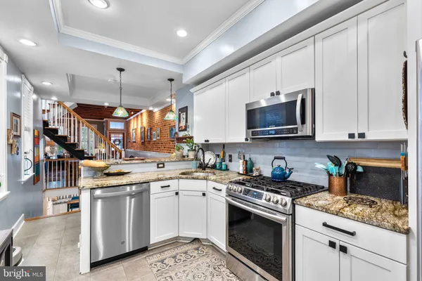 a kitchen with stainless steel appliances granite countertop a sink and stove top oven