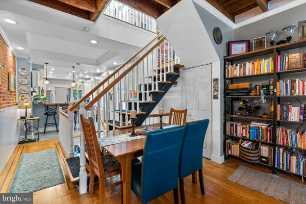a dining room with furniture a book shelves and wooden floor
