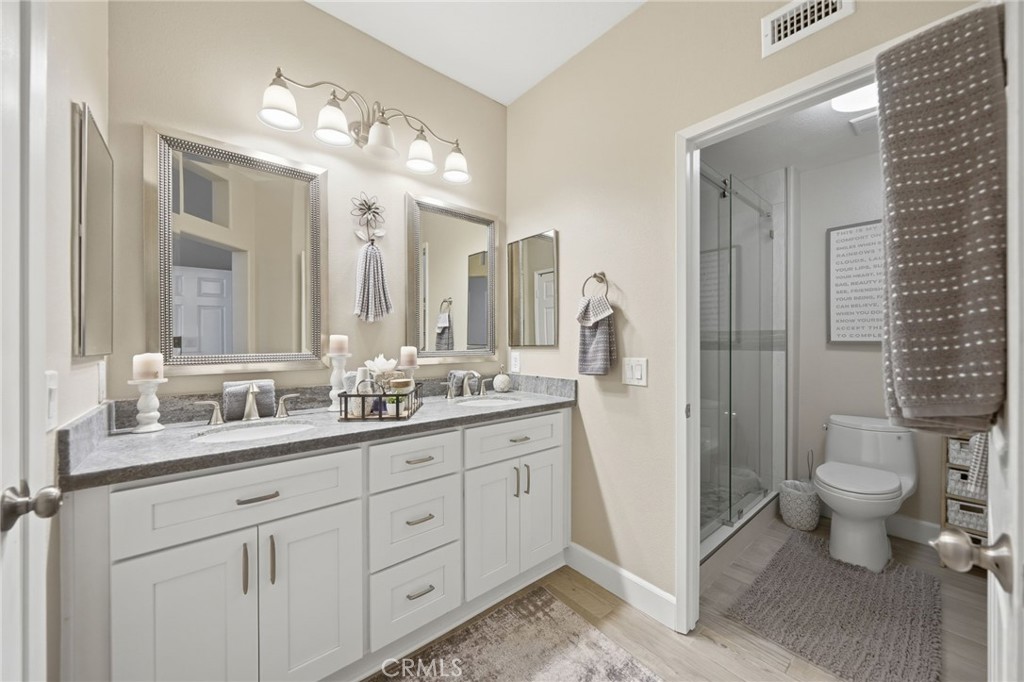 33433 Emerson Way, Unit A Temecula, CA 92592 - Photo 13 of 31 a spacious bathroom with a double vanity sink toilet and a mirror