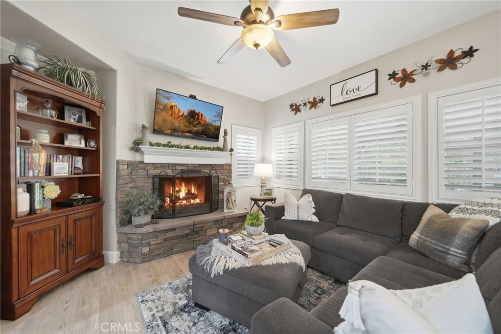 33433 Emerson Way, Unit A Temecula, CA 92592 - Photo 2 of 31 a living room with furniture a fireplace and a flat screen tv