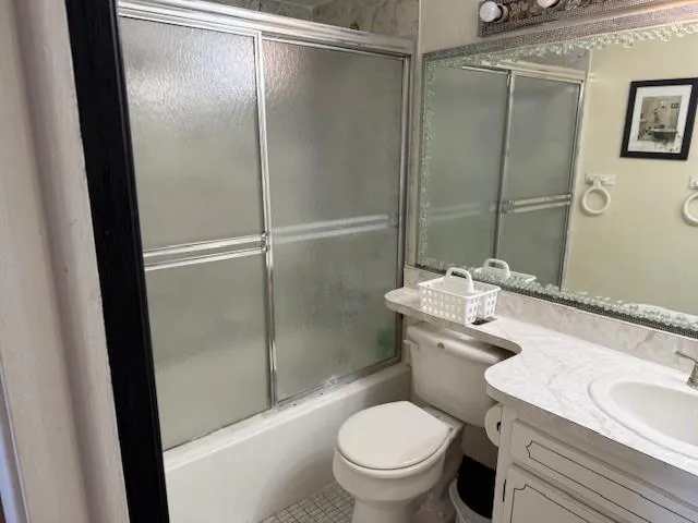 a bathroom with a granite countertop toilet sink and a mirror