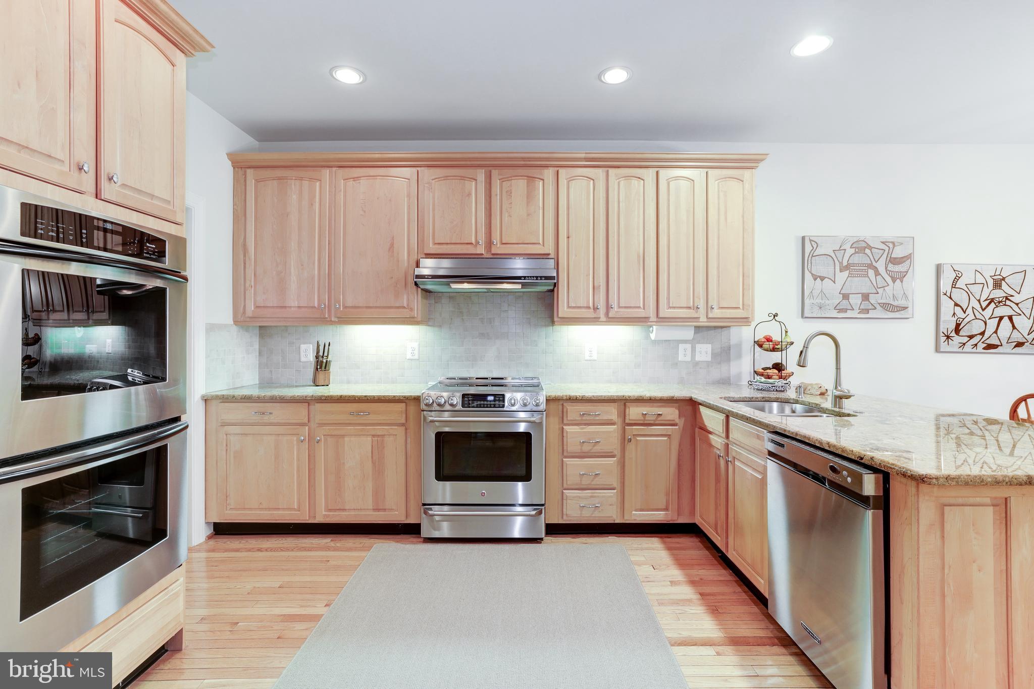 20135 Valhalla Square Ashburn, VA 20147 - Photo 12 of 41 a kitchen with stainless steel appliances granite countertop a stove top oven a sink dishwasher and a refrigerator with wooden cabinets