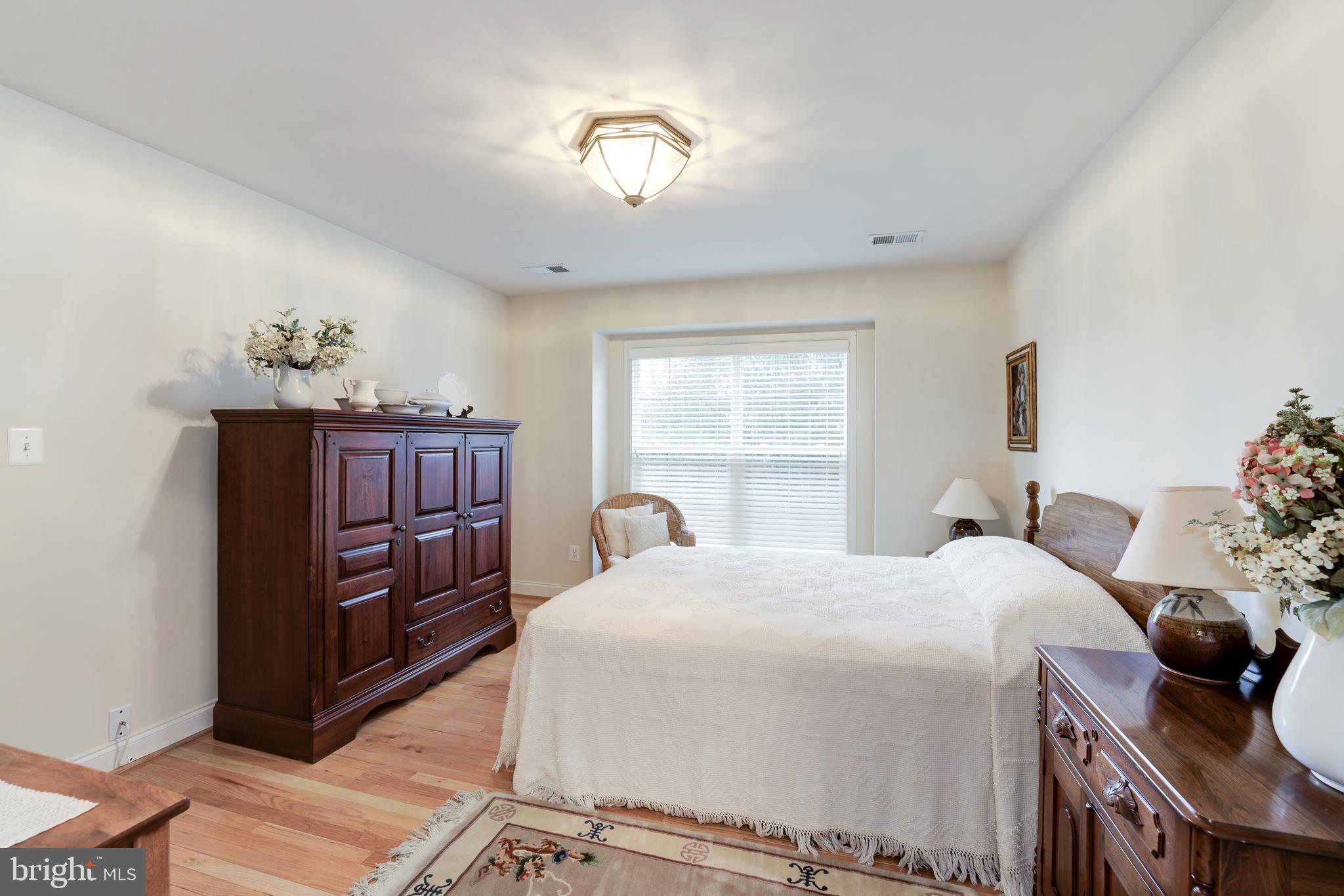 20135 Valhalla Square Ashburn, VA 20147 - Photo 27 of 41 a bedroom with a bed and wooden floor