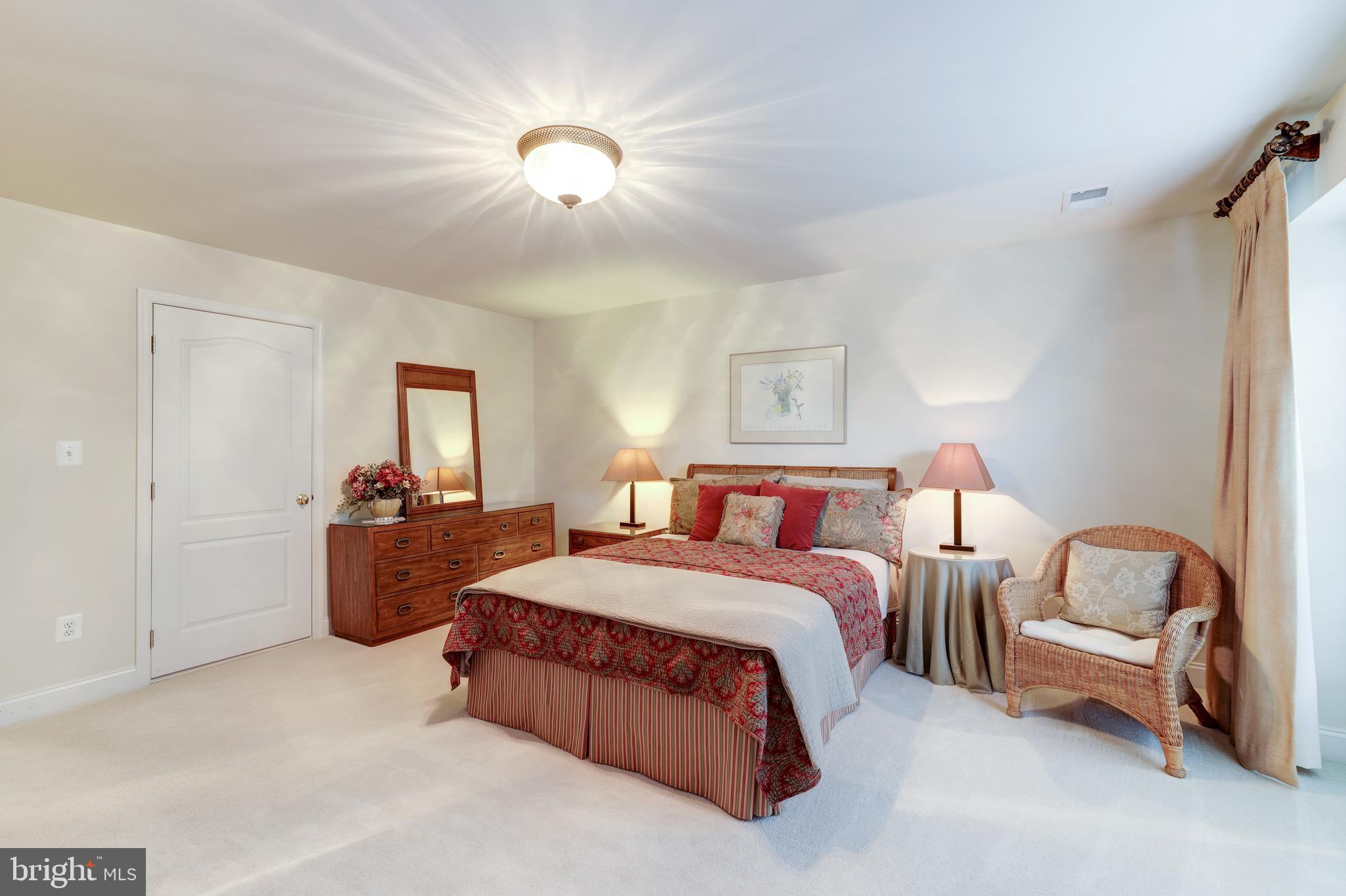 20135 Valhalla Square Ashburn, VA 20147 - Photo 29 of 41 a spacious bedroom with a bed and a chandelier