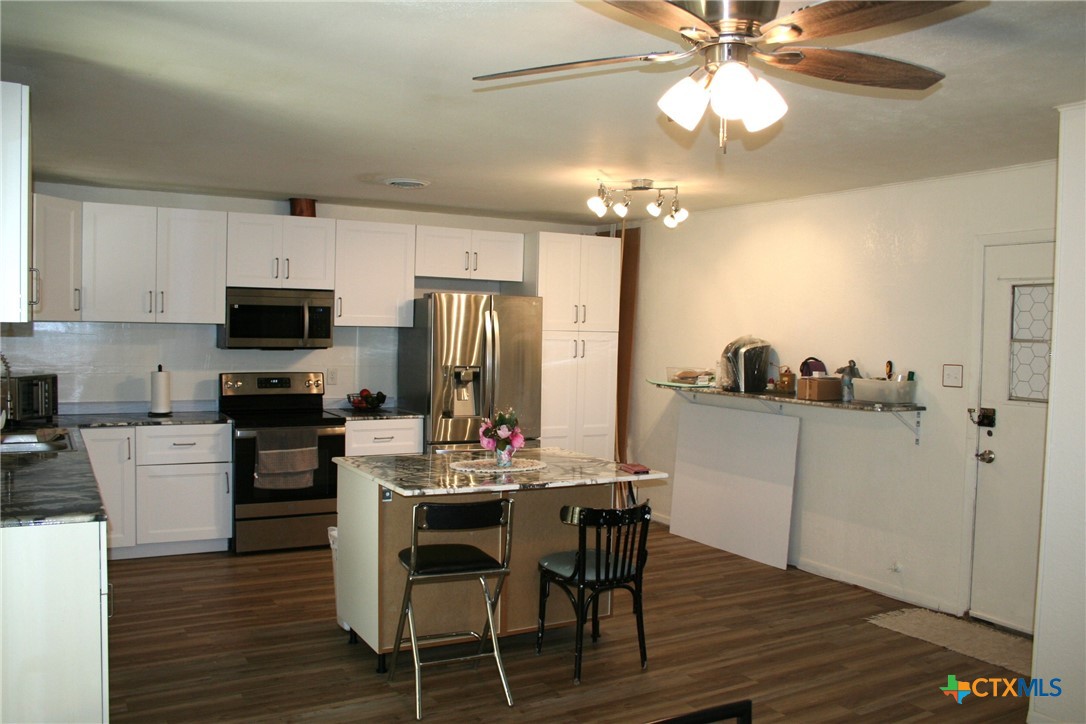 1611 North 10th Street Killeen, TX 76541 - Photo 13 of 31 a kitchen with a dining table cabinets appliances and wooden floor