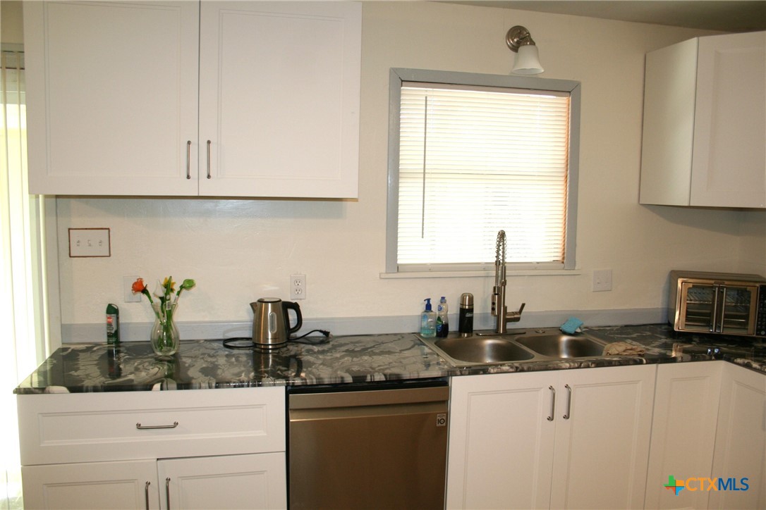 1611 North 10th Street Killeen, TX 76541 - Photo 16 of 31 a kitchen with white cabinets and a window