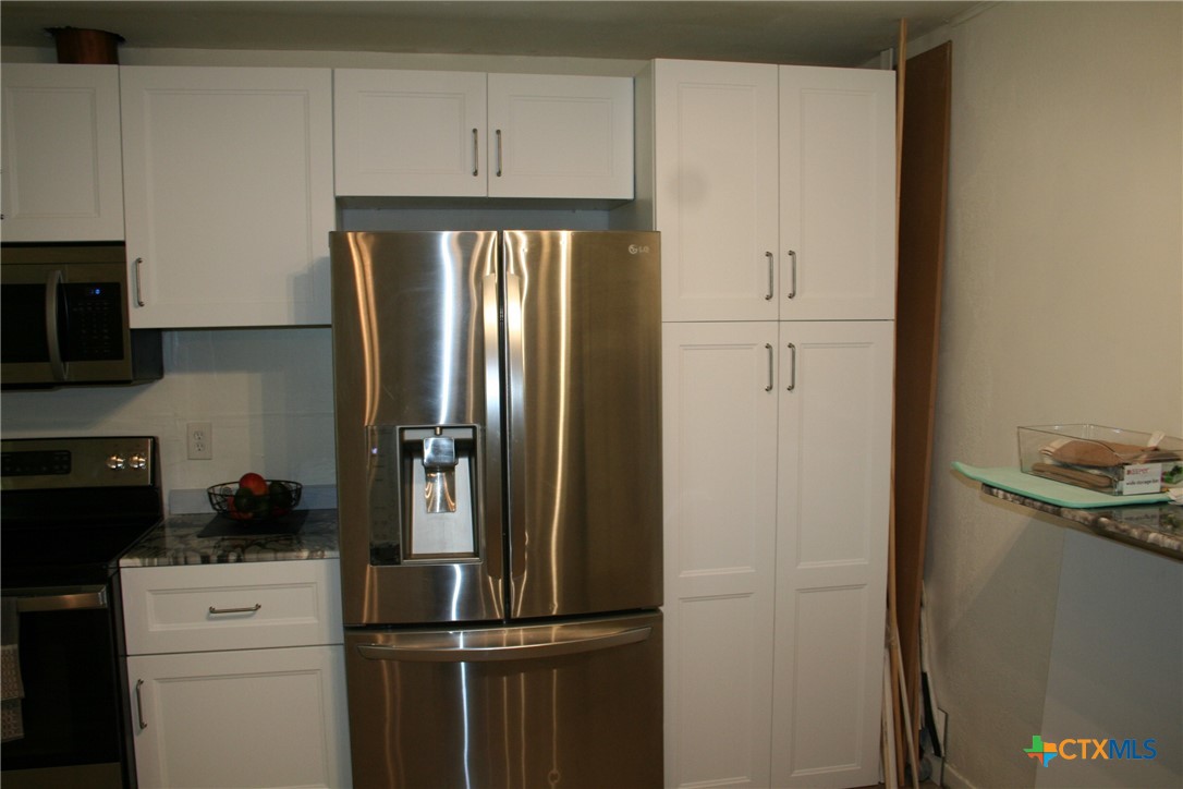 1611 North 10th Street Killeen, TX 76541 - Photo 19 of 31 a kitchen with a refrigerator and cabinets