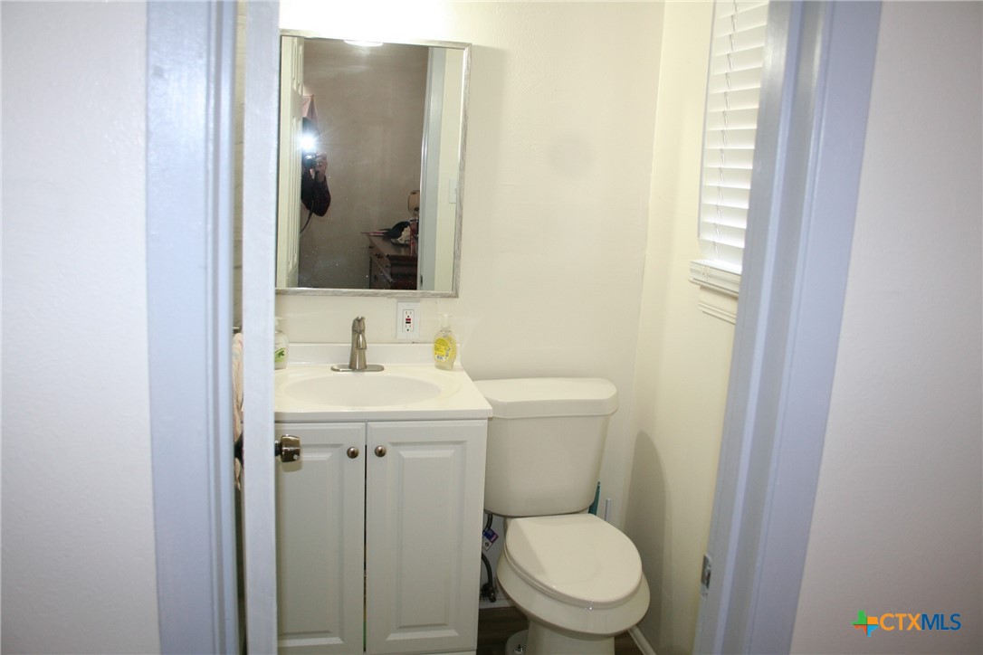 1611 North 10th Street Killeen, TX 76541 - Photo 25 of 31 a bathroom with a toilet a sink and mirror