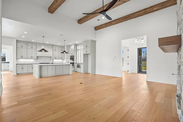 a view of a kitchen with white cabinets and wooden floor