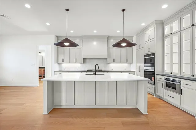 a large kitchen with kitchen island a sink a stove a oven a counter space and a window