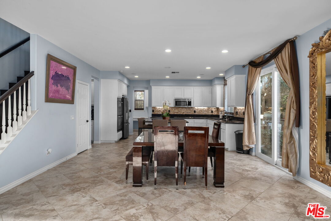 18080 Tanzanite Road San Bernardino, CA 92407 - Photo 13 of 49 a view of kitchen with stainless steel appliances refrigerator stove dining table and chairs