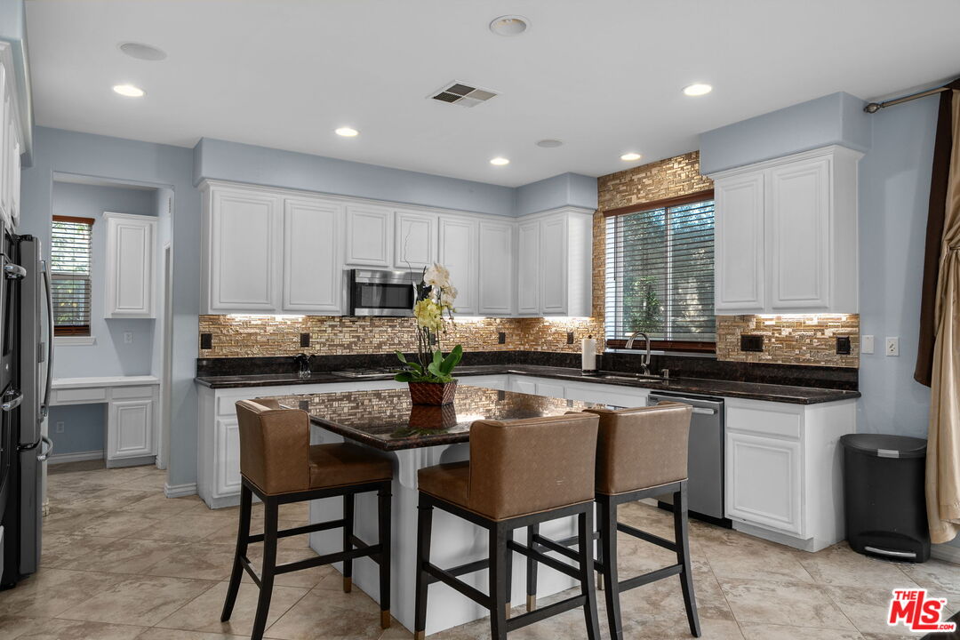 18080 Tanzanite Road San Bernardino, CA 92407 - Photo 14 of 49 a kitchen with granite countertop sink table and chairs