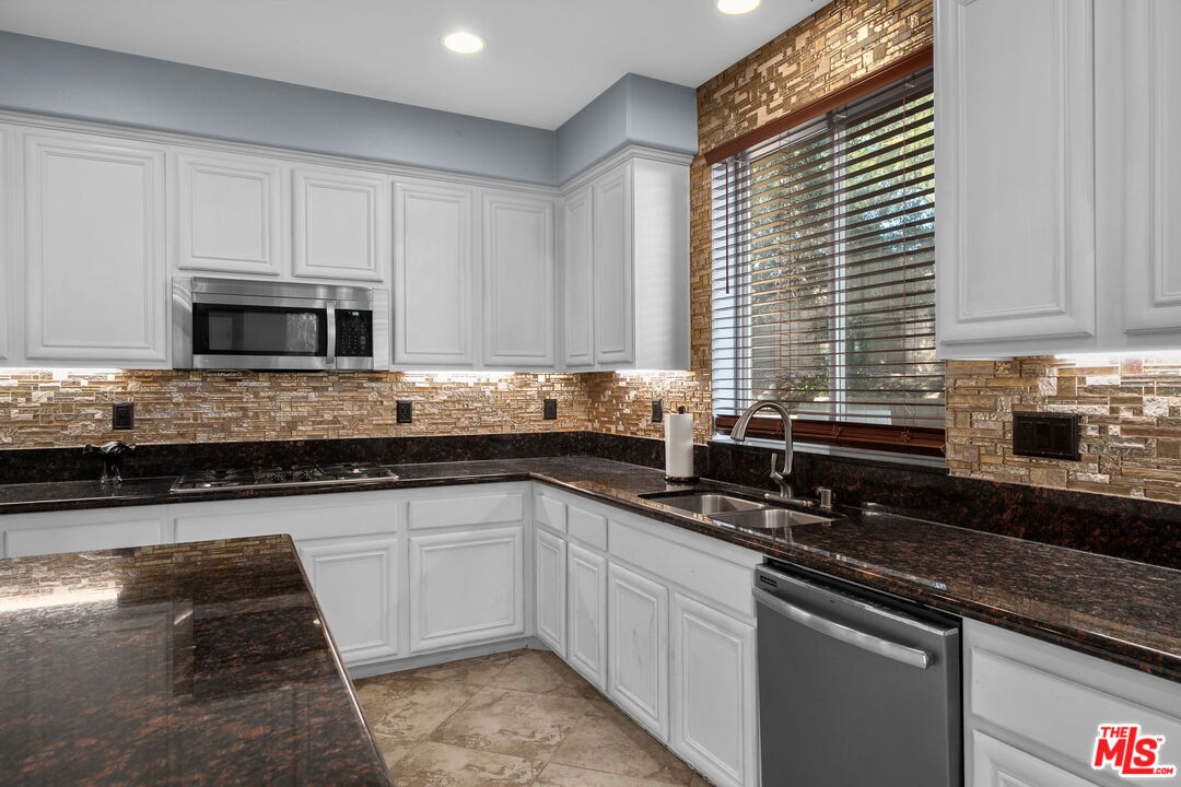 18080 Tanzanite Road San Bernardino, CA 92407 - Photo 18 of 49 a kitchen with sink a microwave and cabinets