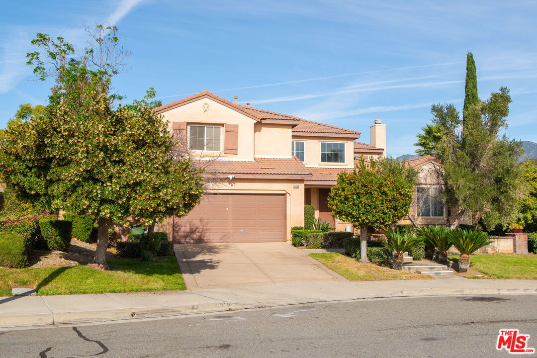 18080 Tanzanite Road San Bernardino, CA 92407 - Photo 2 of 49 a front view of a house with a yard and garage