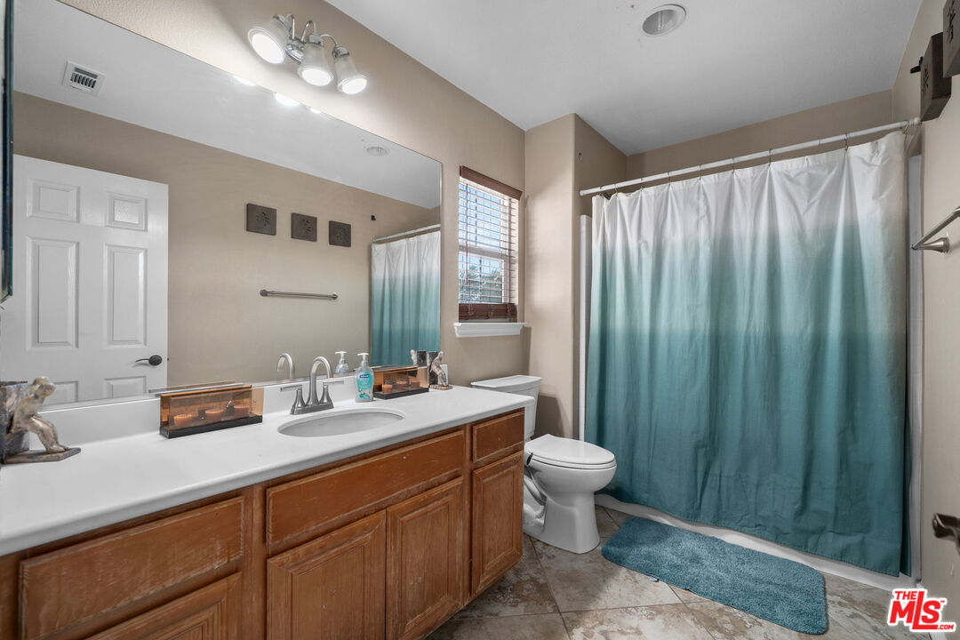 18080 Tanzanite Road San Bernardino, CA 92407 - Photo 32 of 49 a bathroom with a double vanity sink toilet and a mirror