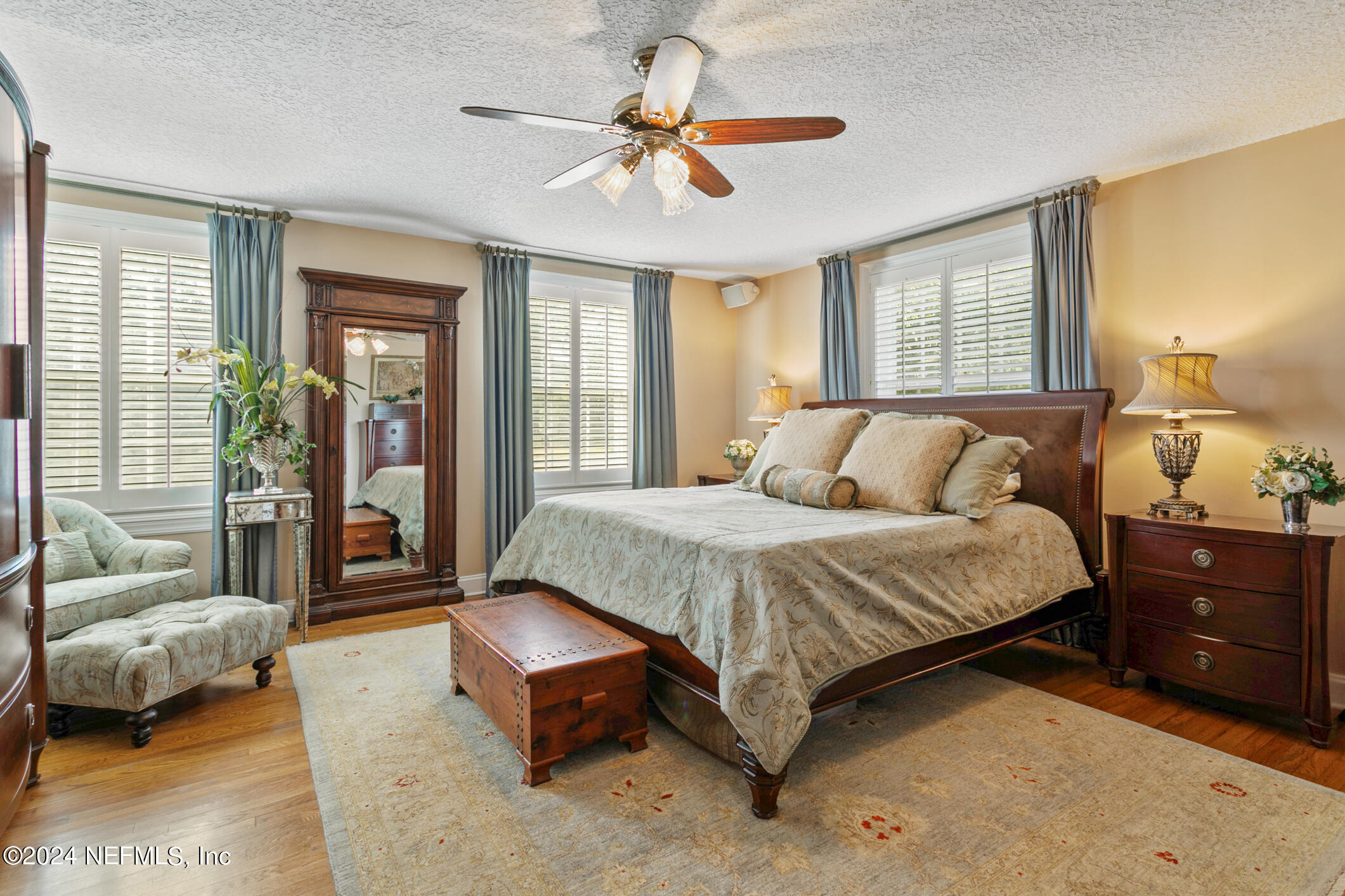 1111 Greenridge Road Jacksonville, FL 32207 - Photo 26 of 73 a spacious bedroom with a bed a couch and a chandelier fan