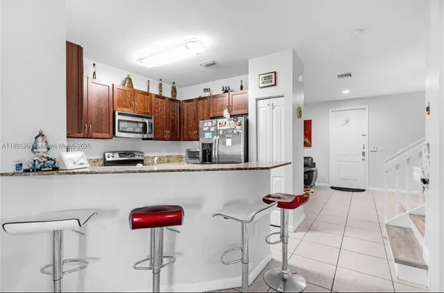 a kitchen with stainless steel appliances granite countertop a refrigerator and cabinets