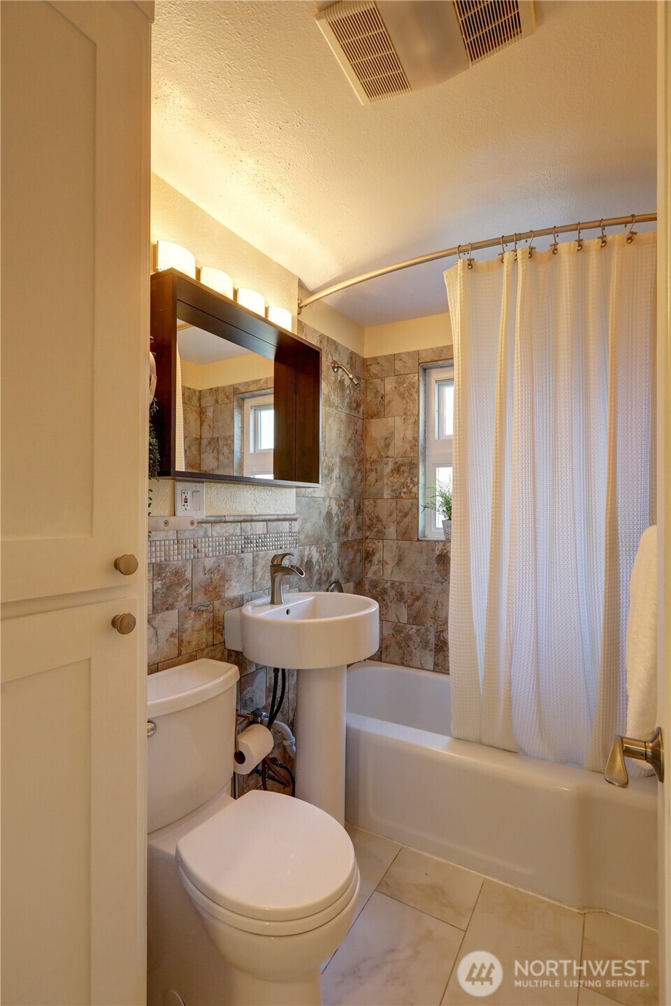 7943 31st Avenue Southwest Seattle, WA 98126 - Photo 11 of 16 a bathroom with a sink a toilet and shower