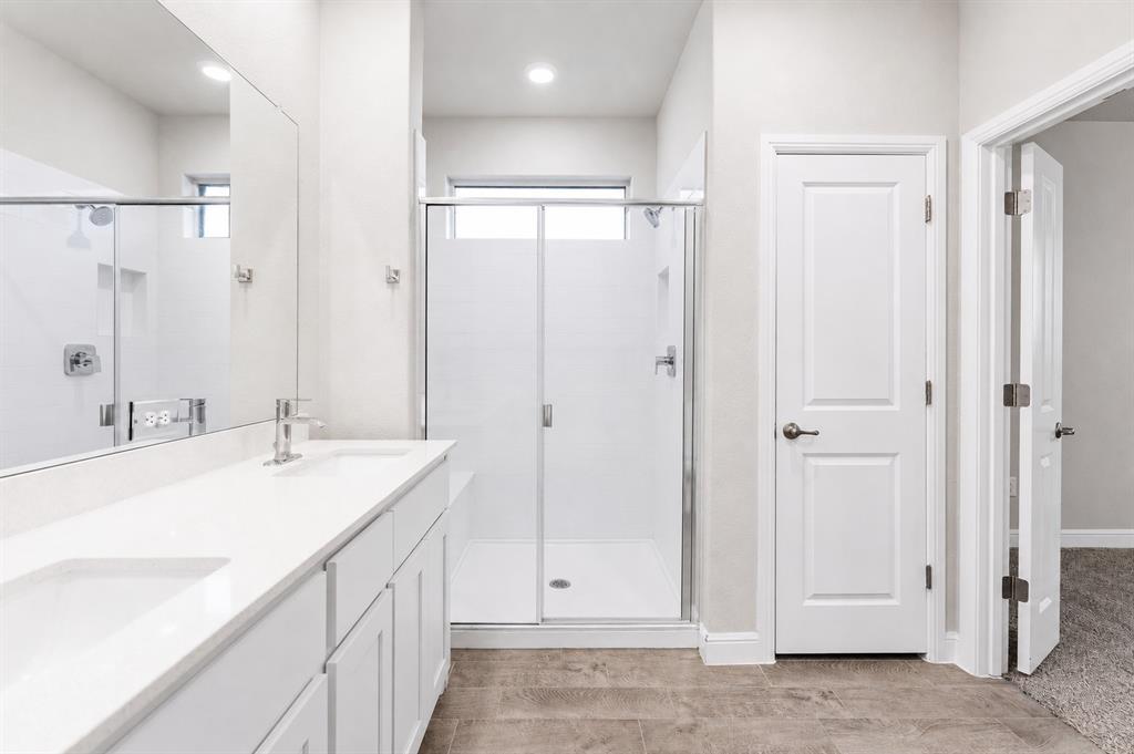1804 Mensa Drive Haslet, TX 76052 - Photo 14 of 30 Bathroom featuring a dual vanity with white countertops and integrated sinks, a walk-in shower with a glass enclosure, and modern tile flooring