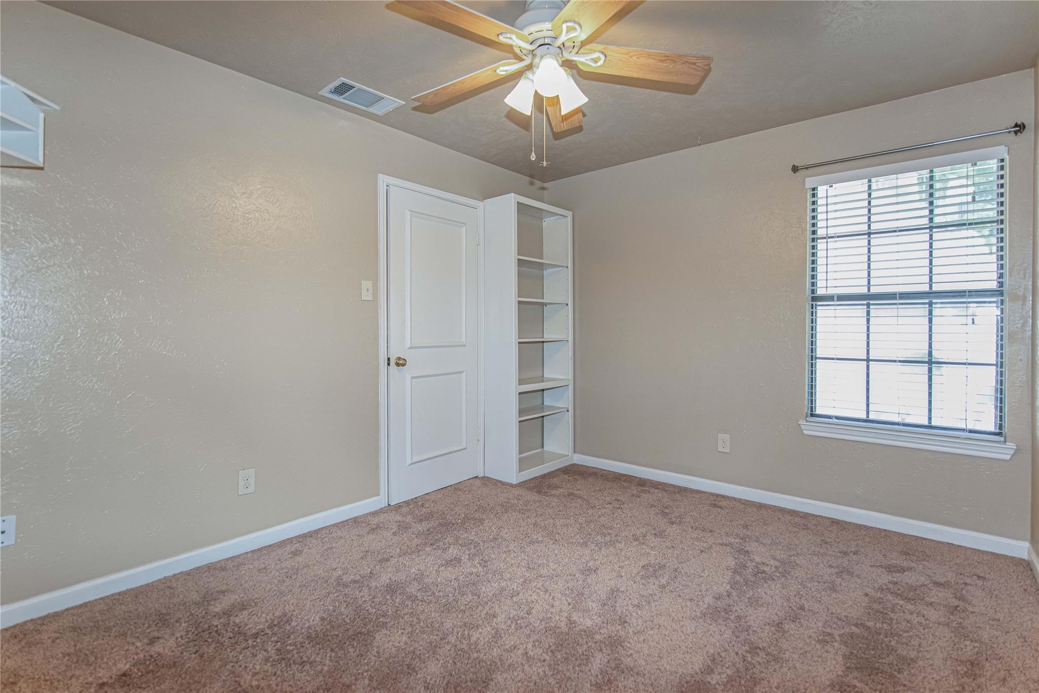 10131 Wayward Wind Lane Houston, TX 77064 - Photo 13 of 16 an empty room with windows and fan