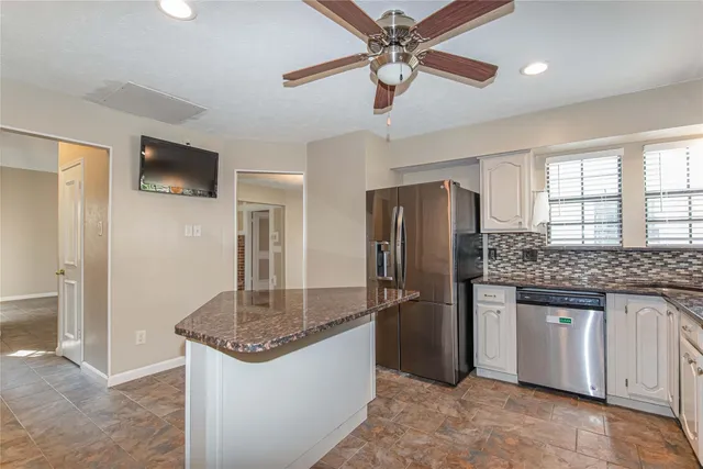 a kitchen with stainless steel appliances granite countertop a refrigerator a stove and a sink