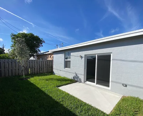a backyard of a house with plants and wooden fence