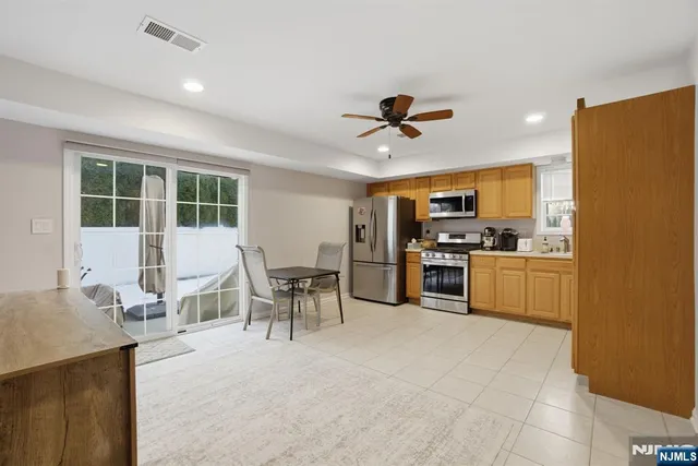 a open kitchen with cabinets table and stainless steel appliances