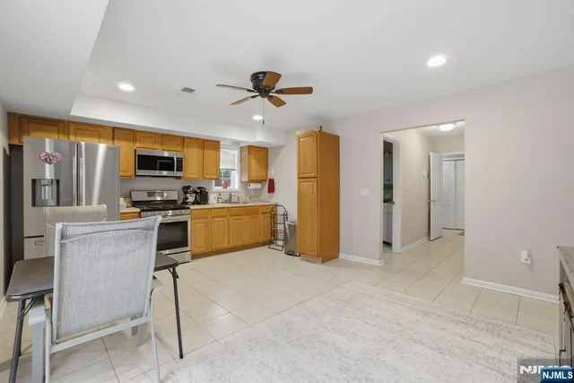 a kitchen with stainless steel appliances kitchen island granite countertop a refrigerator and a stove top oven
