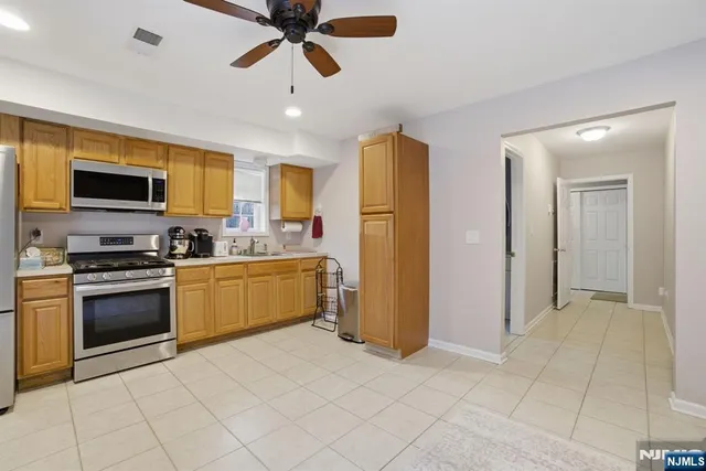 a kitchen with a refrigerator a sink and a stove top oven
