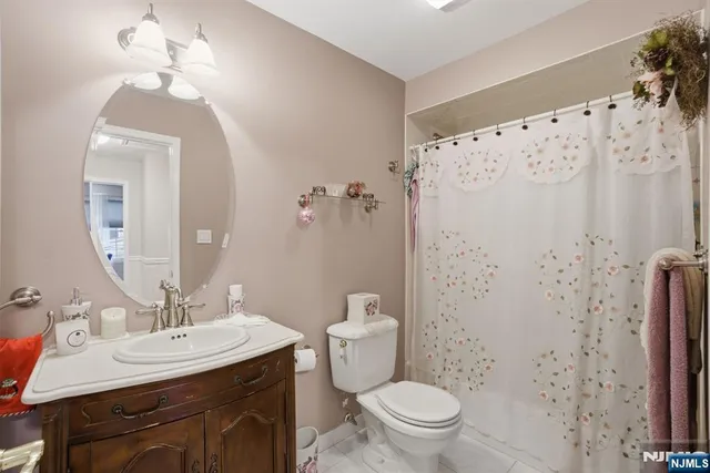 a bathroom with a sink toilet a mirror and shower curtain