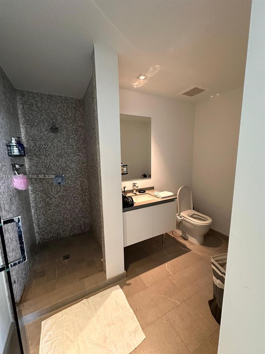 88 Southwest 7th Street, Unit 810 Miami, FL 33130 - Photo 8 of 10 a bathroom with a sink a toilet and shower
