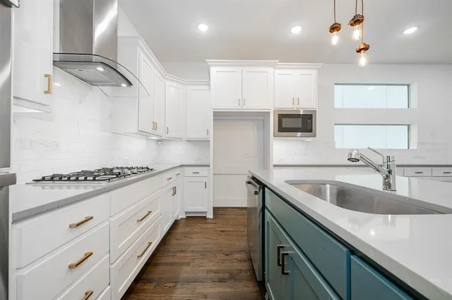 a kitchen with granite countertop a sink stainless steel appliances and cabinets