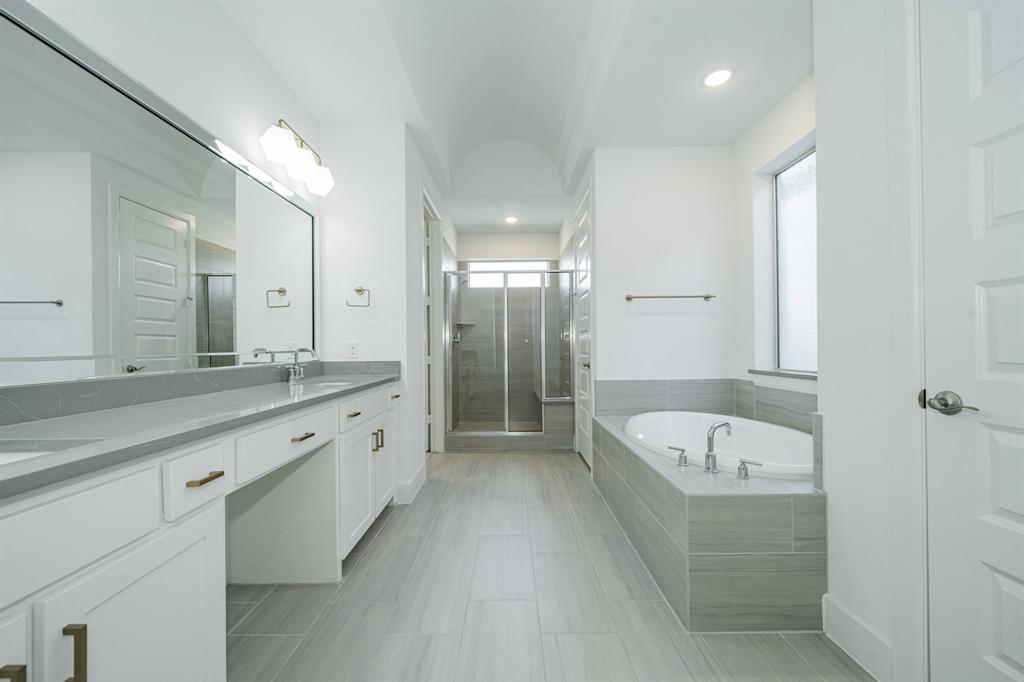 8106 Fallston Court Dallas, TX 75231 - Photo 28 of 40 a bathroom with a tub a double vanity sink and mirror