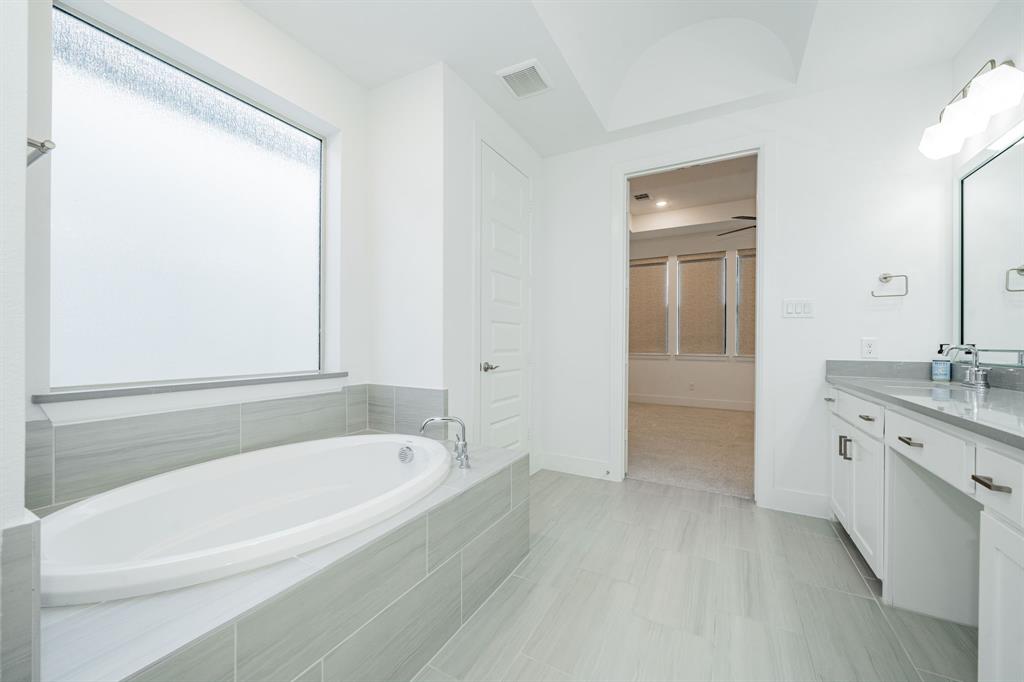 8106 Fallston Court Dallas, TX 75231 - Photo 29 of 40 a white bath tub sitting next to a bathroom sink