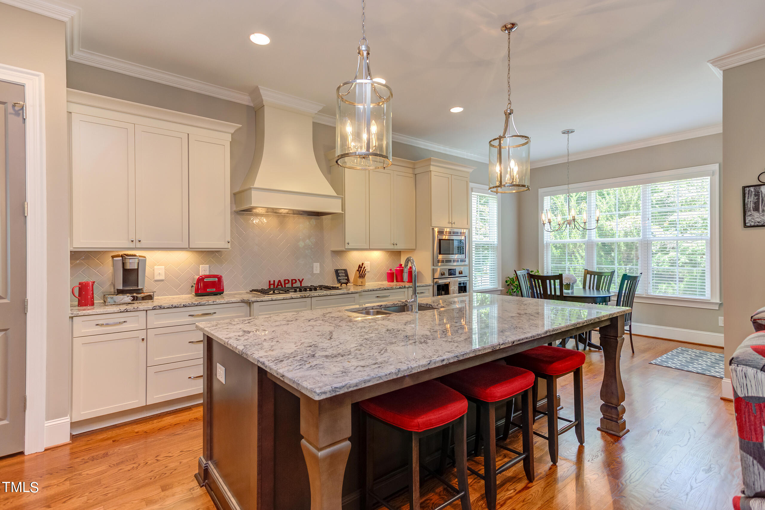 6426 Rosny Road Raleigh, NC 27613 - Photo 12 of 51 a kitchen with stainless steel appliances granite countertop a stove a refrigerator a sink dishwasher and white cabinets with wooden floor