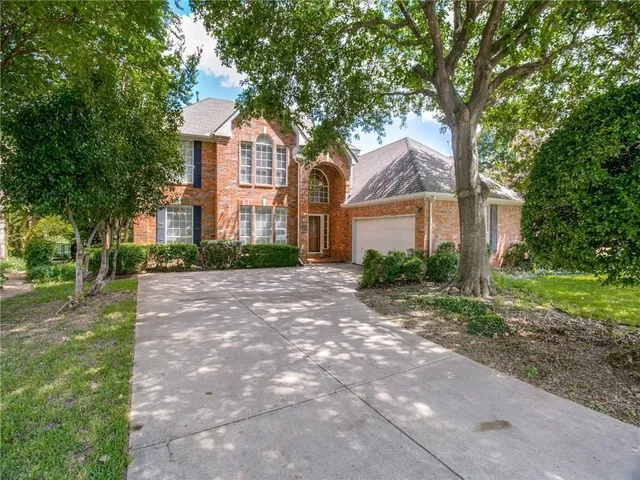 a front view of a house with a yard and a garden