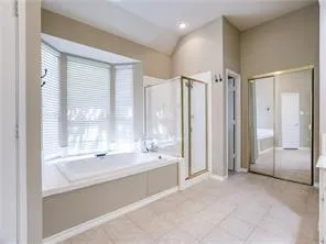 a spacious bathroom with a tub shower and sink