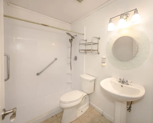 a bathroom with a sink a toilet and shower