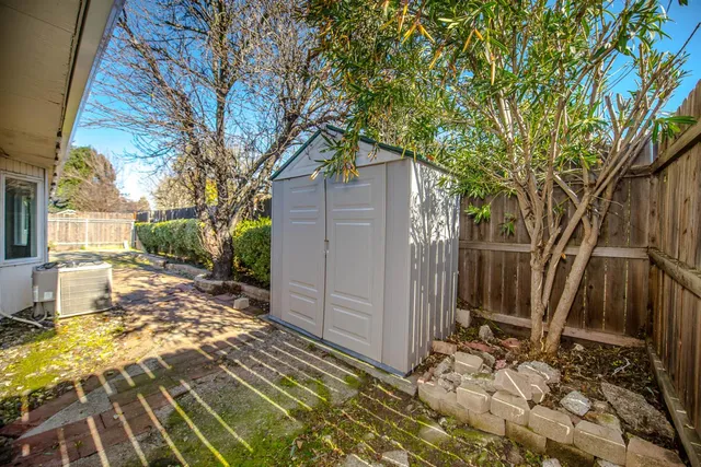 a view of a house with backyard and trees