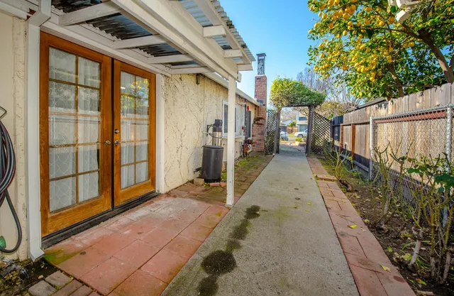 a view of a patio with table and chairs with wooden floor and fence