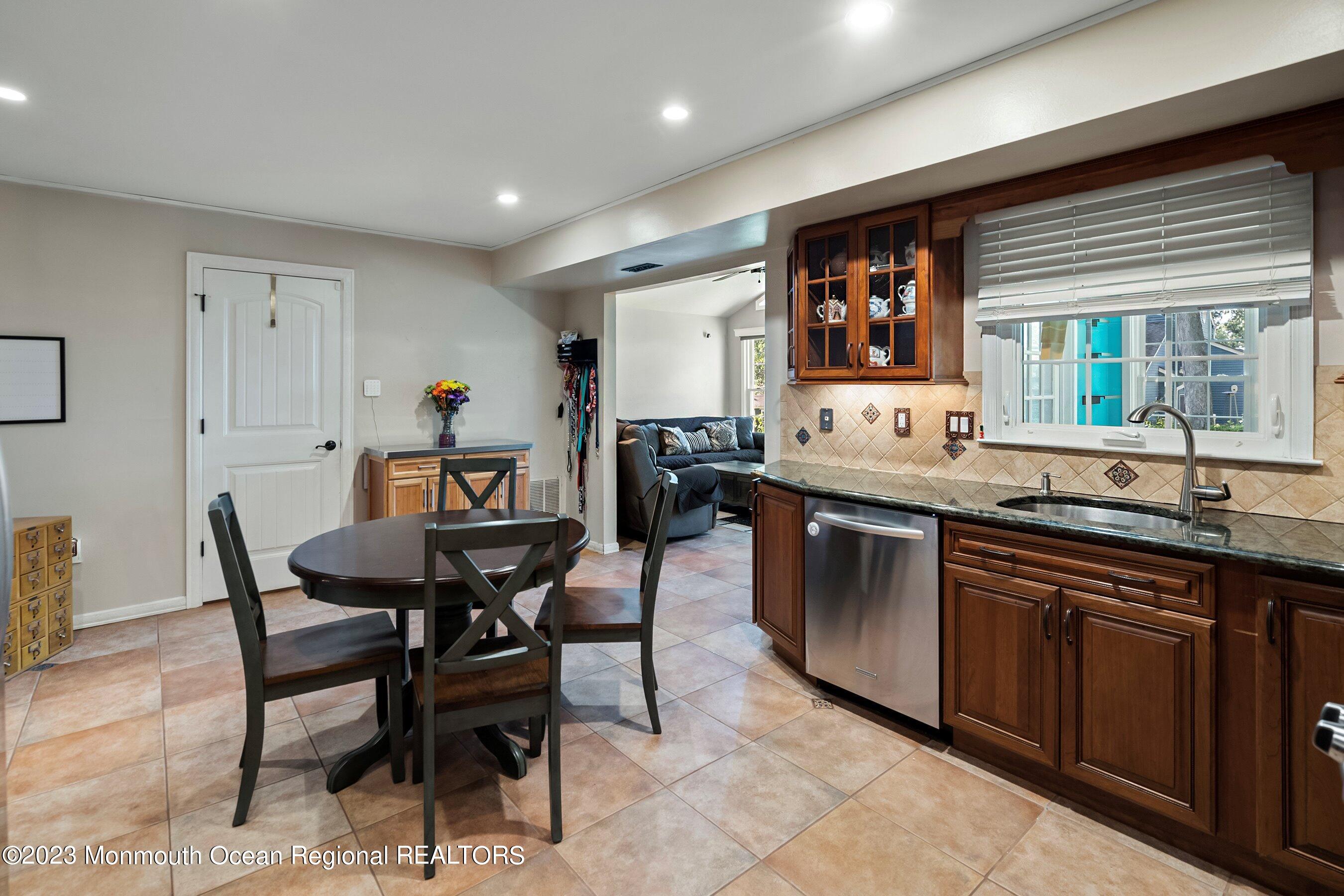 3 Adams Court Howell, NJ 07731 - Photo 17 of 36 a dining hall with stainless steel appliances granite countertop a sink a stove a dining table and chairs