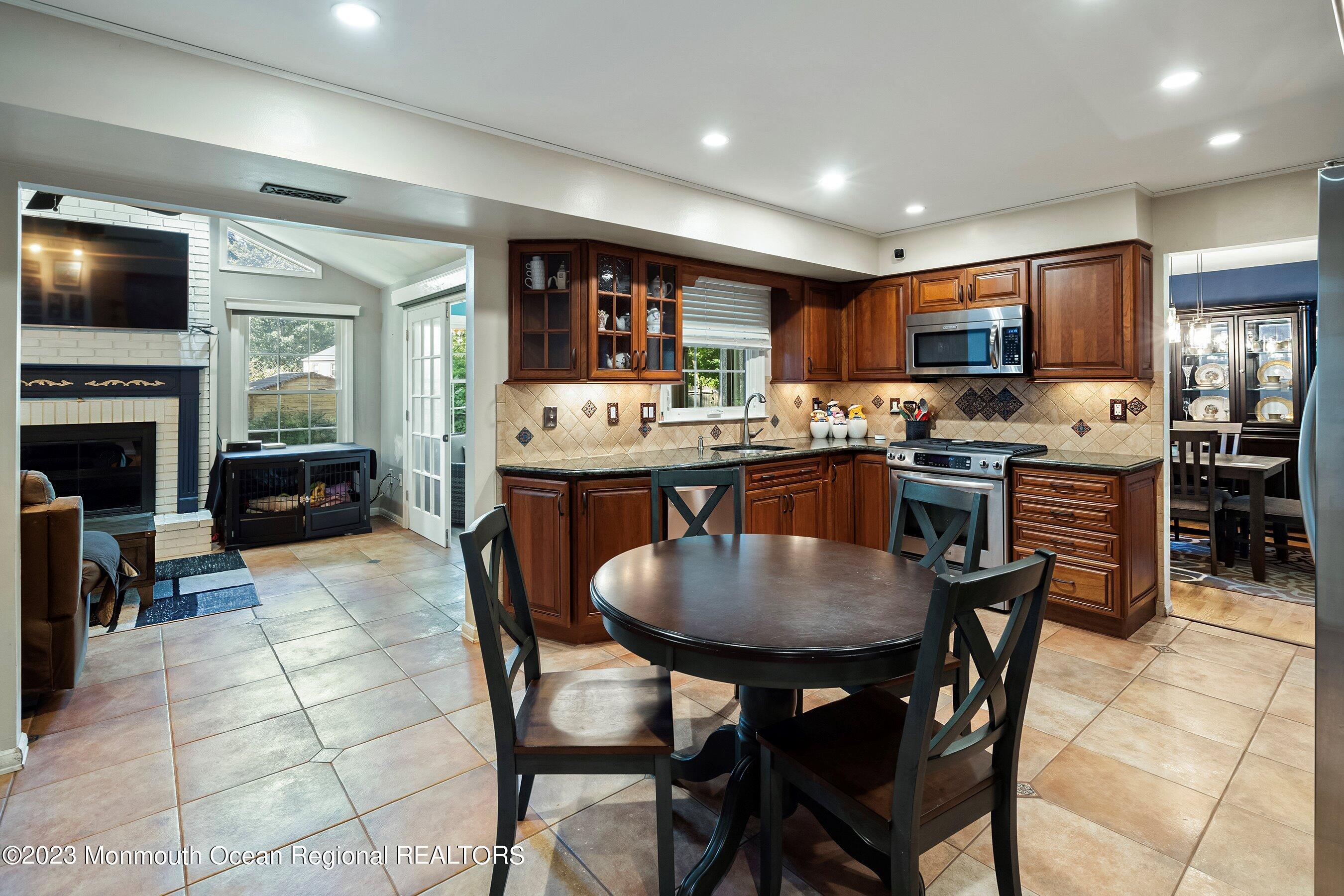 3 Adams Court Howell, NJ 07731 - Photo 18 of 36 a kitchen with stainless steel appliances granite countertop a stove a sink a microwave a dining table and chairs