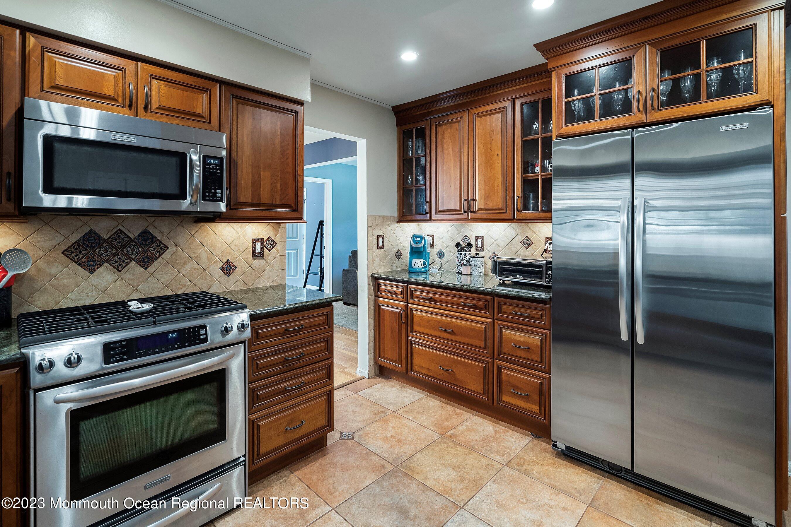 3 Adams Court Howell, NJ 07731 - Photo 19 of 36 a kitchen with stainless steel appliances granite countertop a stove microwave and refrigerator
