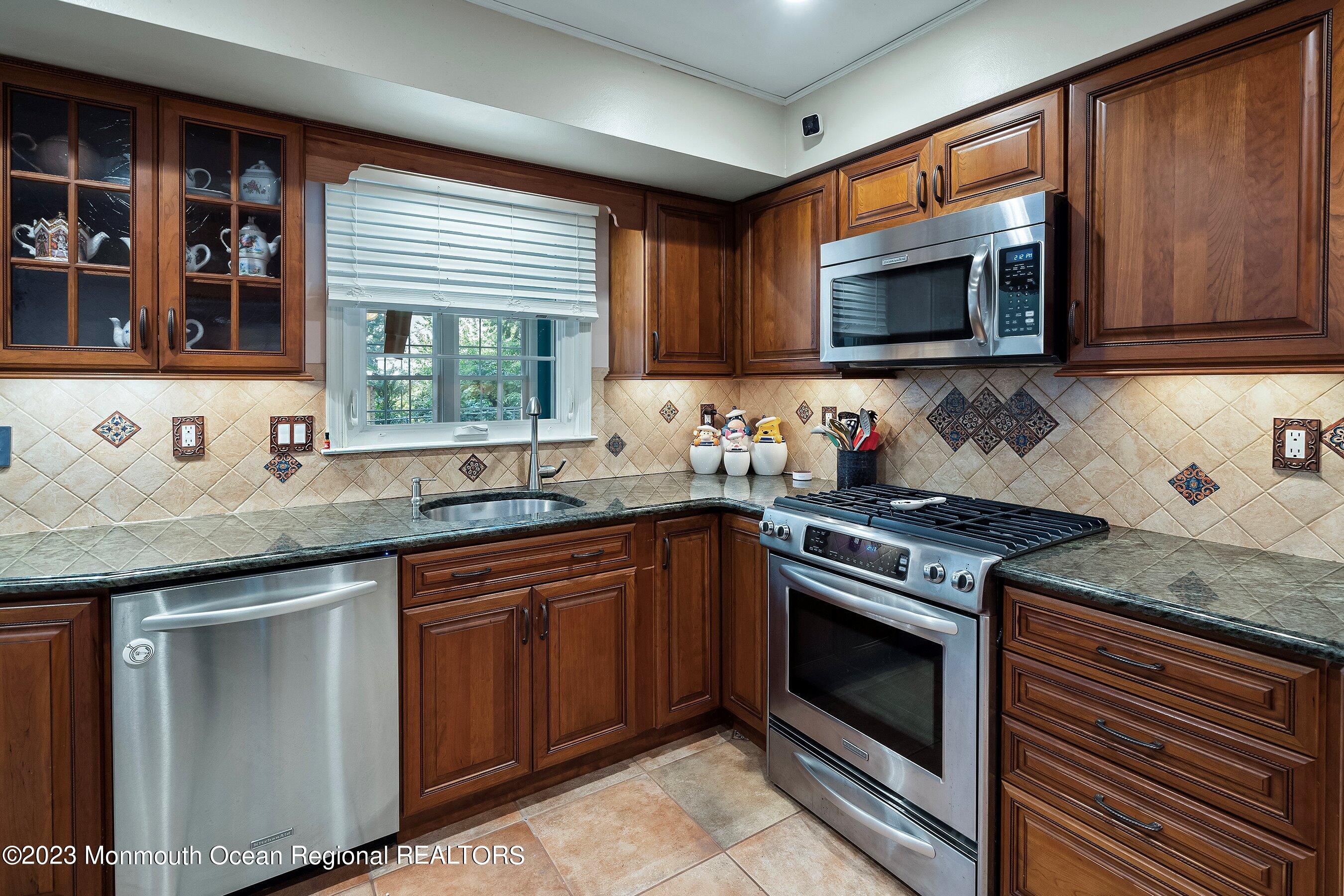 3 Adams Court Howell, NJ 07731 - Photo 21 of 36 a kitchen with stainless steel appliances granite countertop a stove sink and microwave